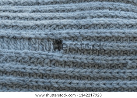 gray texture of woolen fabric with a hole