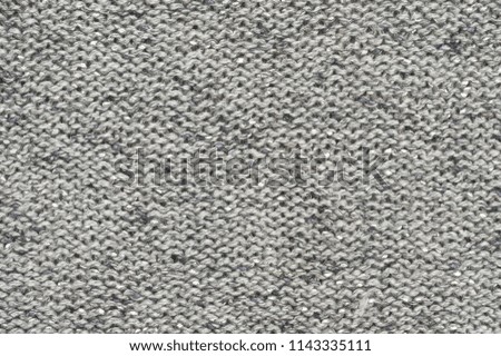 Rough woolen grey knit texture as background.