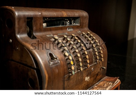 Vintage cash register on a black background.