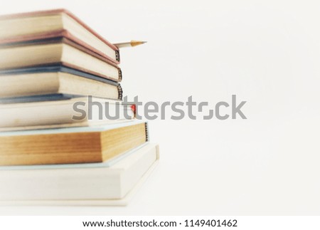 A pencil is on Book Stack on white background in education abstract concept.