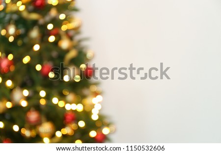 Blurred view of Christmas tree with fairy lights on white background