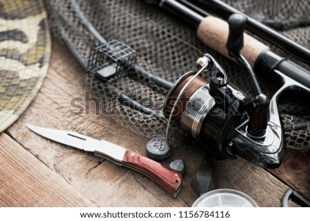 Fishing tackle. Fishing rod isolated. Close up of feeder fishing reel on wooden table.