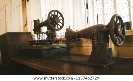 The silhouette of an ancient sewing machine attached to a window.