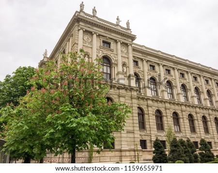 blooming chestnut near a beautiful building, beautiful building, cloudy weather, young flowering trees