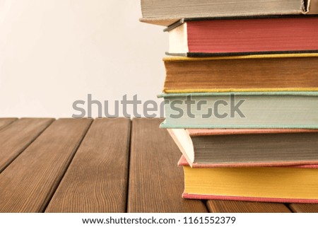 Stack of books on a wooden table. The concept of education and knowledge from books. Close up. With empty space for text