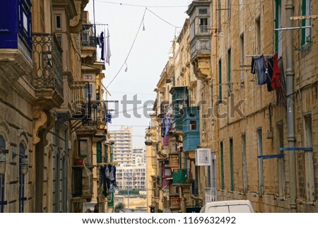 Laundry hanging from apartments on narrow street in Valletta, Malta