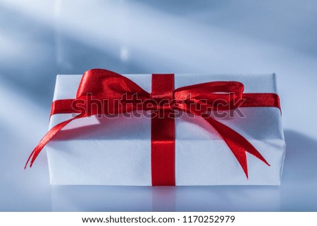 Red gift box with knot on white background.