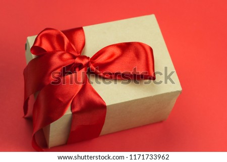 gift box with red satin ribbon on a red background