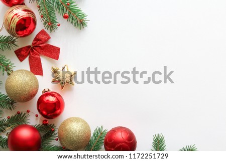 Christmas festive composition with fir branches, red and gold christmas decorations and copy space on white background, top view, flat lay.
