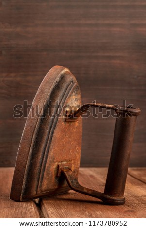A side view of a vintage iron on a dark rustic background with copy space
