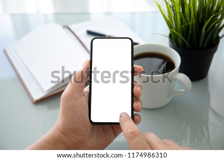man hands holding phone with isolated screen over table in the office 