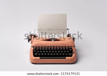 Stylish retro typewriter with a paper sheet on the light background in the studio. Horizontal.