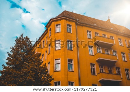 dark colored corner building with orange facade and small lens flare on the side