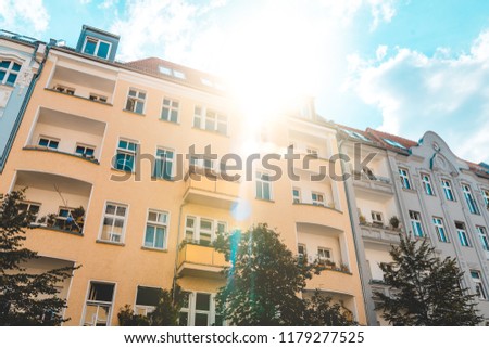 yellow and grey apartment house at prenzlauer berg with big lens flare on the top