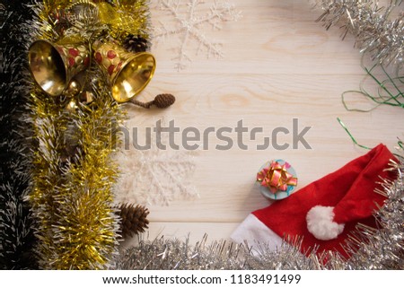 Christmas decorations background with lights, snowflakes, tinsel and bells lie on wooden texture. Top view with empty space.