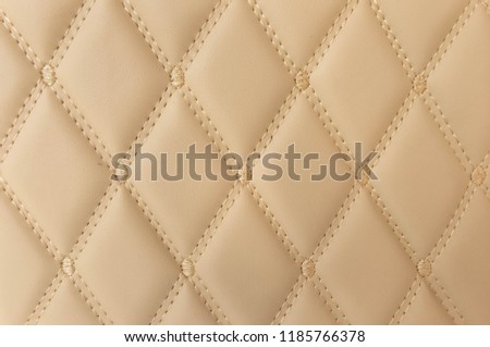 classic beige leather Mat with straight beige stitching soft leather for machine with textured pattern concept background fabric business