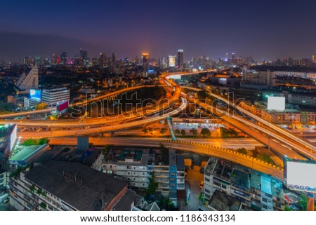 Aerial view of highway interchange junction in Bangkok city downtown at sunset with cityscape background, Bangkok, Thailand.