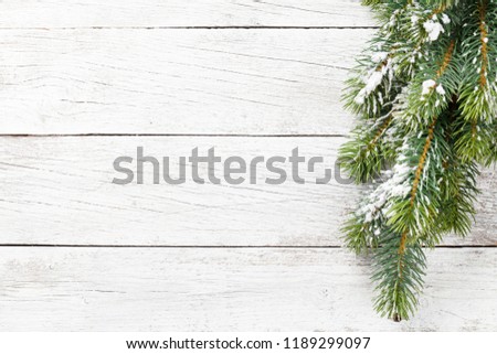 Christmas snow fir tree on wooden table. Top view with space for your greetings