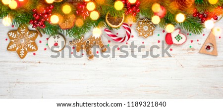 Glittered сhristmas background, decorated holiday tree branches and gingerbread cookies