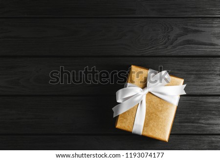 top view of a gift box on a black wooden background, gifts on a black table a flat lay, a festive concept