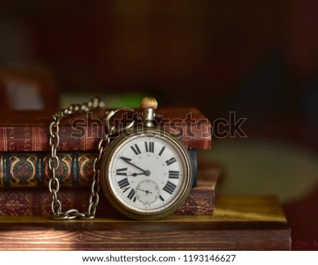Old pocket watch with chain and old books