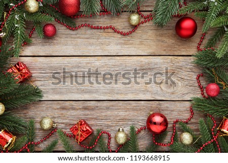 Fir-tree branches with christmas decorations on wooden table