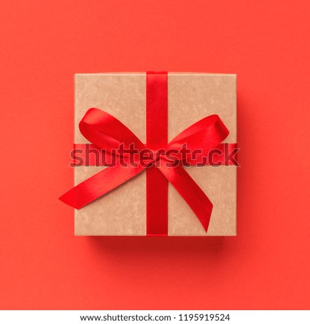 Wrapped vintage gift box with ribbon bow on red background