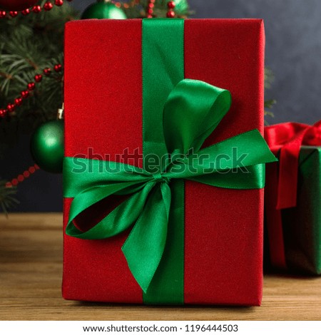 Green red gifts under the tree, on the table, against the wood background. The concept of Christmas and New Year.
