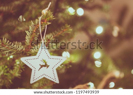 Wooden bauble on christmas tree with bokeh light.