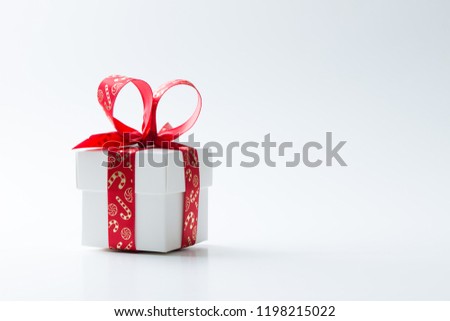 One white gift box tied with a red Christmas theme ribbon isolated on white background