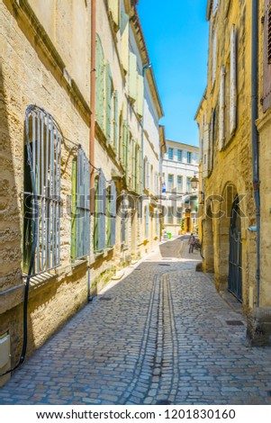 View of a narrow street in the center of Uzes, France
