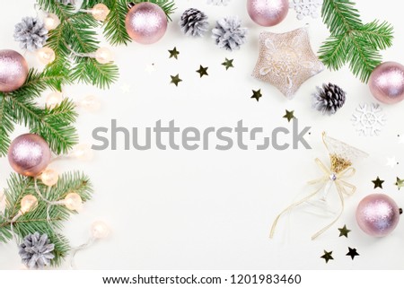 Christmas background with fir tree branches, pink and beige decorations, silver ornaments. Copy space