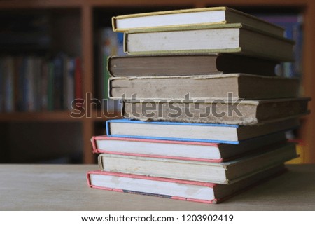Close-up of old books stacked on table in library bookshelf is the background selective focus and shallow depth of field