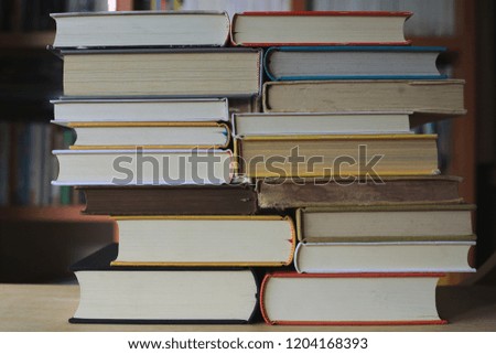 Close-up of several books stacked on a table in a library selective focus and shallow depth of field