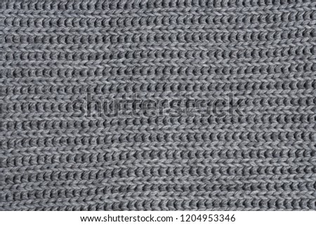 Grey woolen knitted scarf. Closeup view texture.