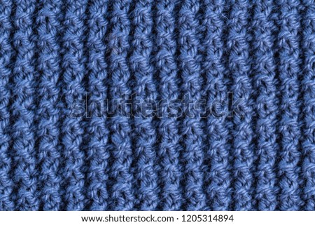 The texture of a blue knitted yarn. Knitted and winter clothes 
