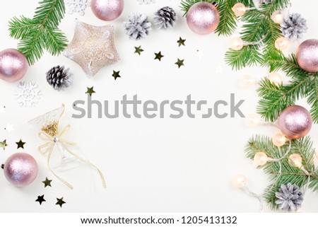 Christmas background with fir tree branches, Christmas lights, pink and beige decorations, silver ornaments