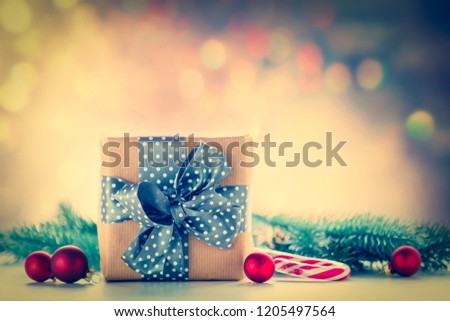 Christmas gift and baubles with pine branch on dark background