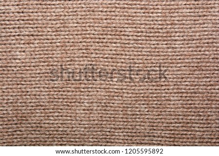 The texture of the knitted beige fabric for the background