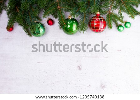 Evergreen fir tree twigs with red and green decorations, flat lay boder on white wooden background