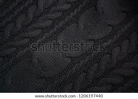 Black woolen knitted textile detail with diagonal patterns