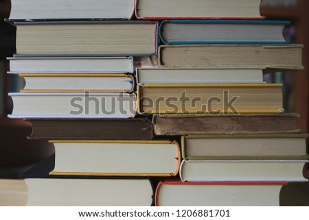Close-up of several books stacked on a table in a library selective focus and shallow depth of field