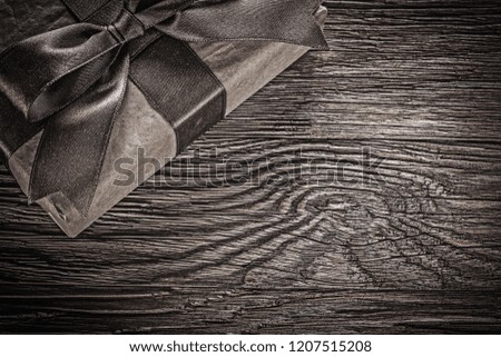 Brown wrapped present box on vintage wooden board.