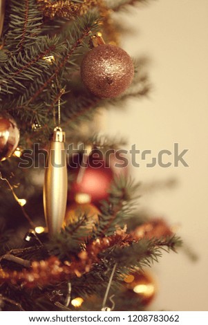 Christmas tree with toys. Christmas and New Year background.Festive decor in golden tones on the Christmas tree. Winter season