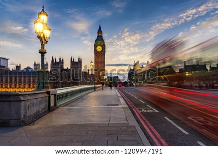 The Westminster Bridge and Big Ben clocktower by the Thames river in London after sunset with blurred traffic, United Kingdom