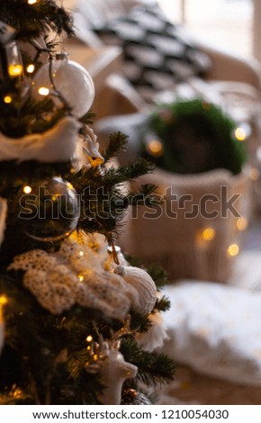 Close up view of a Christmas tree with beautiful neutral colored decorations and garland lights