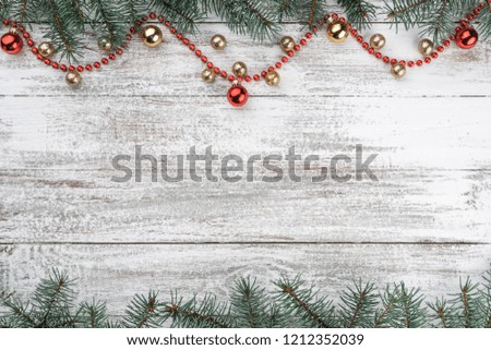 Old wooden Christmas background. Fir branches. Gold and red baubles. Red garlands. Top view. Space for your text. Xmas card.