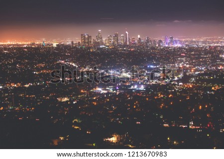 Beautiful super wide-angle night aerial view of Los Angeles, California, USA, with downtown district, mountains and scenery beyond the city, seen from the observation deck of Griffith Park observatory