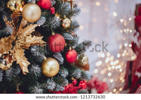 Christmas tree with toys. Christmas balls on the tree in red and gold color.