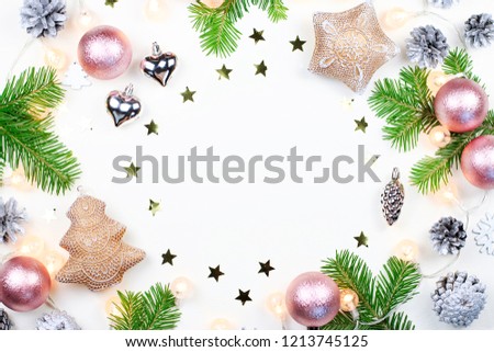 Christmas background with fir tree branches, Christmas lights, pink and beige decorations, silver ornaments